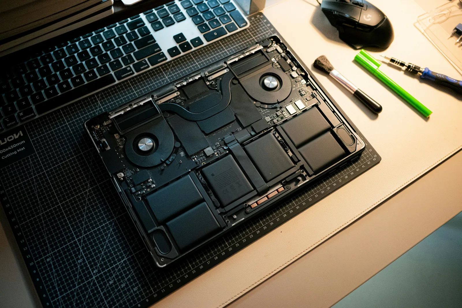 Laptop opened for internal maintenance on a work mat